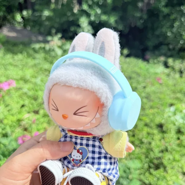 Cute Labubu Doll Wearing a Blue Headphone in a Natural Green Setting - Adorable Earphone Accessory | Labubu Doll Clothing & Accessories