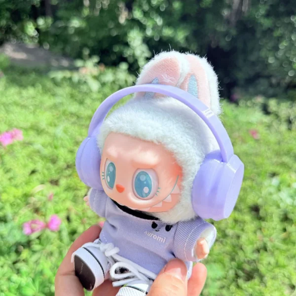 Cute Labubu Doll Wearing a Purple Headphone in a Natural Green Setting - Adorable Earphone Accessory | Labubu Doll Clothing & Accessories
